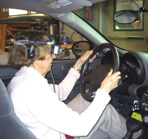 Older driver behind the wheel of the Driving Simulator - inside-the-cabin shot